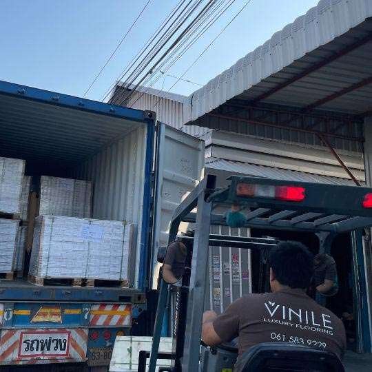Bfloor Expertise worker unloading high-quality flooring products from a shipping container.